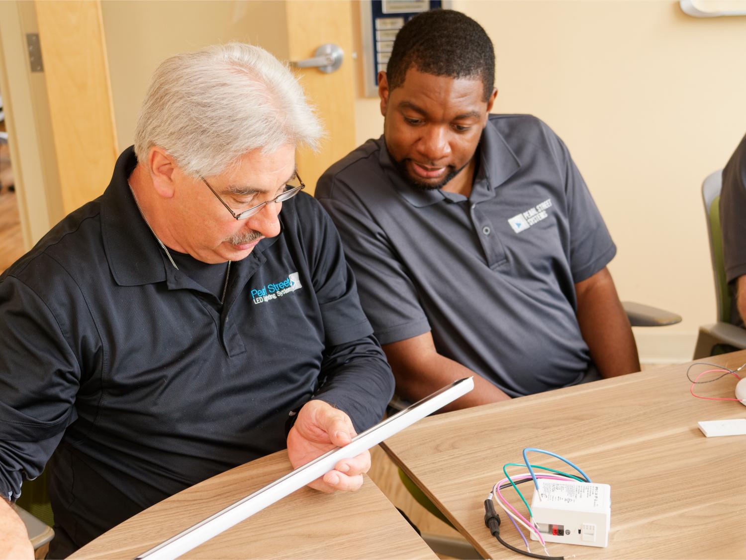 Two pearl street employees inspecting a lighting module