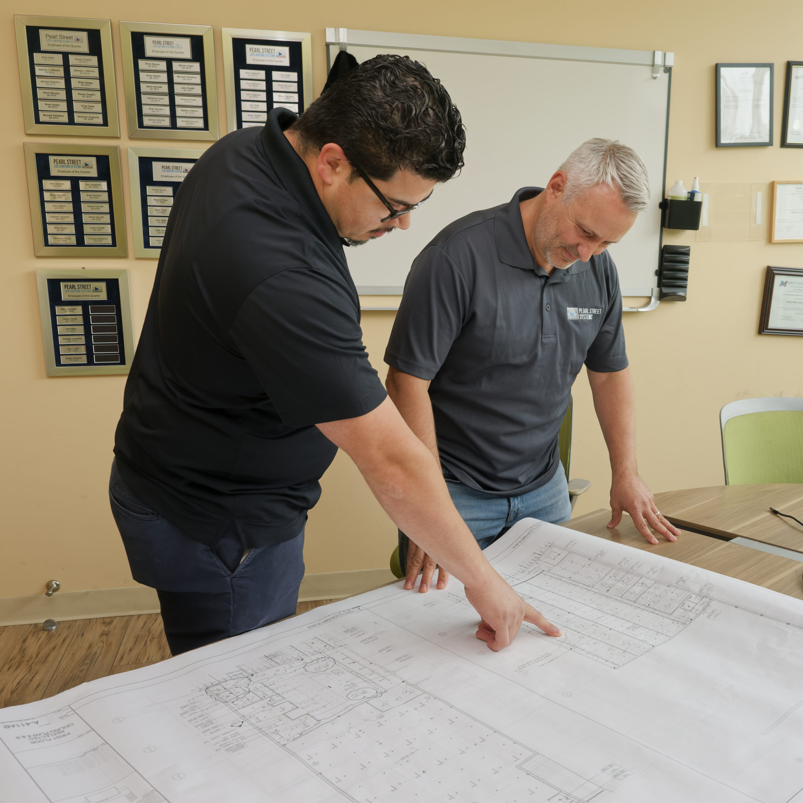 Pearl Street LED Lighting employees looking at blueprints